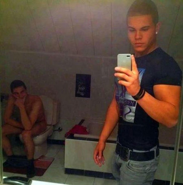 With your friend sitting on the toilet, you take a selfie.